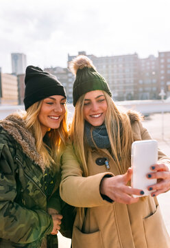 Two friends taking selfie with smartphone
