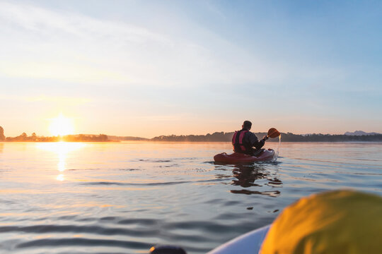 Woman standing on sup board in the morning on a lake, Germany