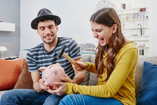 Couple in furniture store demolishing piggy bank