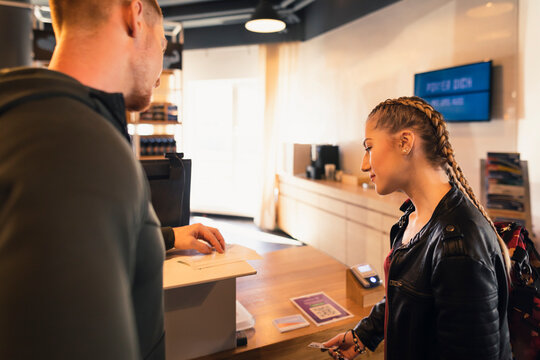 Young woman looking at application form at front desk of a gym