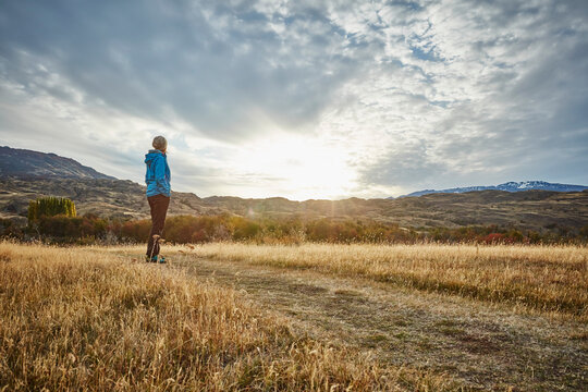 Chile, Valle Chacabuco, Parque Nacional Patagonia, woman standing in steppe landscape at sunset