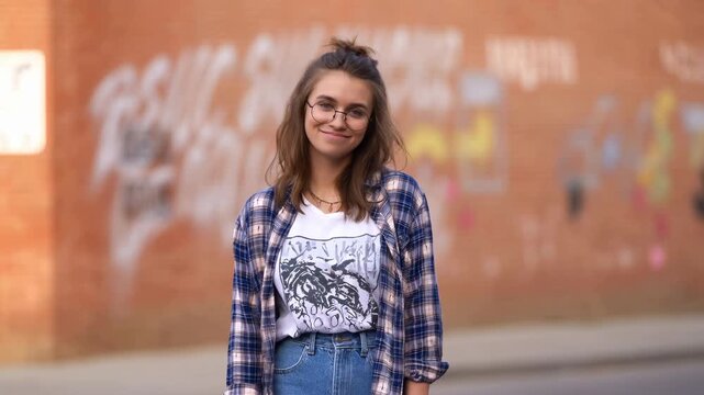 Vibrant Candid Shot Of Young Woman Sporting Fashionable Clothes Against Colorful City Graffiti Background