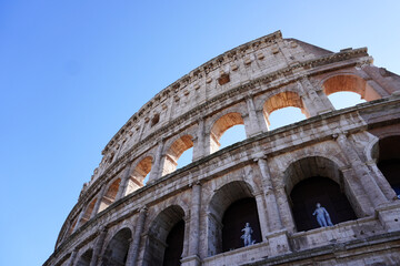 Obraz premium Colosseum (Coliseum) building or Flavian Amphitheatre in Rome, Lazio, Italy. Architectural monument of Ancient Rome. Close up view of the Colosseum, highlighting arches and aged stone. 