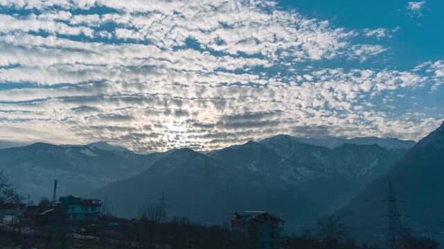4K Time-lapse shot of stratus clouds above the snowy Himalayan mountain range during the winter season as seen from Naggar near Manali in Himachal Pradesh, India. Scenic Natural view of Himalayas.