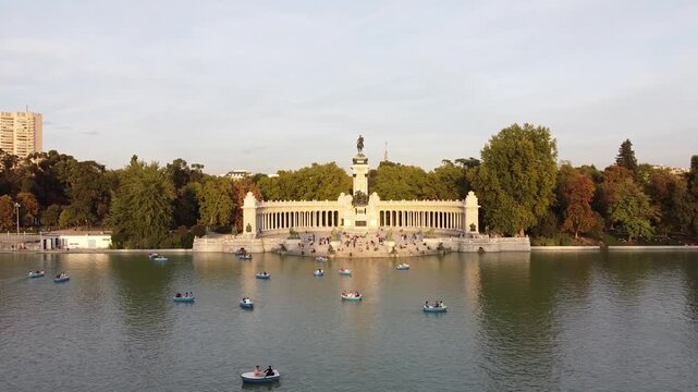 Aerial view of tourists on boats enjoying an autumn day on a great pond in front of monument to Alfonso XII at the Retiro Park (Parque del Buen Retiro) in Madrid, Spain.