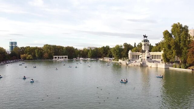 Aerial view of tourists on boats enjoying an autumn day on a great pond in front of monument to Alfonso XII at the Retiro Park (Parque del Buen Retiro) in Madrid, Spain.