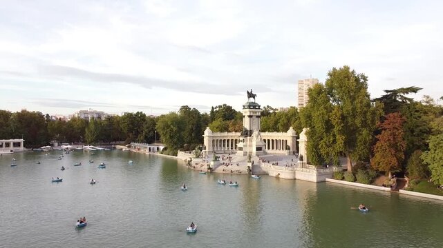 Aerial view of tourists on boats enjoying an autumn day on a great pond in front of monument to Alfonso XII at the Retiro Park (Parque del Buen Retiro) in Madrid, Spain.