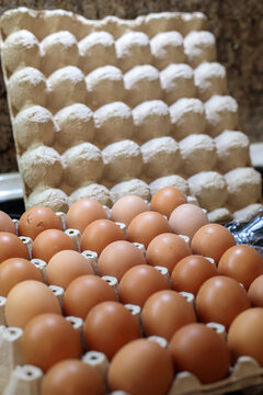 large tray of fresh brown chicken eggs in cardboard carton on kitchen countertop, organic food ingredient for cooking, baking and breakfast preparation in home kitchen