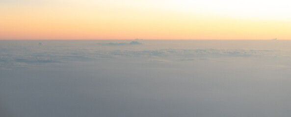 Fototapeta premium Sunrise or sunset sky from an airplane window, view of clouds from above