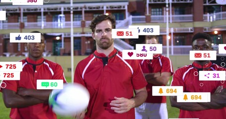 Holding blue-white ball, center posing on grass pitch in red jerseys at stadium, social icons