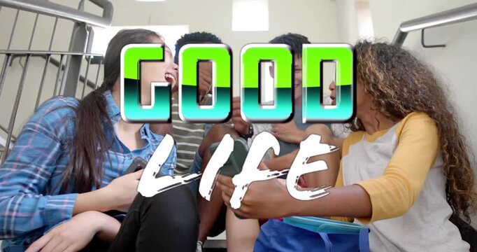 Four teens sitting on school steps, GOOD LIFE title sliding across, leaning, sharing phone content