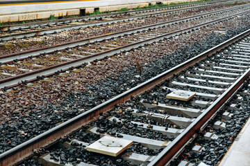 Fototapeta premium Train tracks are wet after rain at a railway station in the morning hours