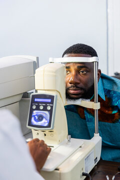 African man undergoing a comprehensive eye check up with a non-contact tonometer (NCT)