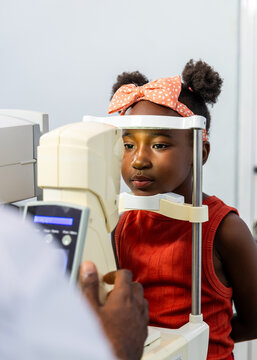 Young African child undergoing vision test with non-contact tonometer (NCT) in a clinic
