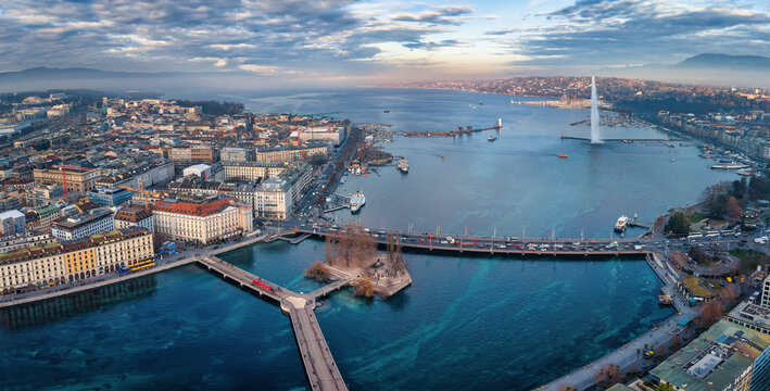Aerial view of the cityscape and lake Geneva, Switzerland, during a winter sunset with fog, clouds and sunshine