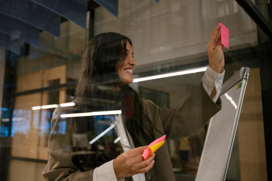 Businesswoman coaching and brainstorming with notes in office