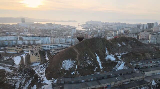 Drone aerial panorama of Vladivostok, Russia, over the Burachka Hill area with urban streets, bridges, sea, and coastal landscape.