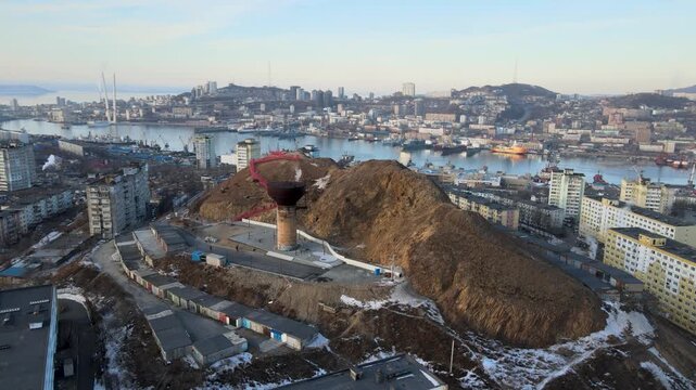 Drone aerial panorama of Vladivostok, Russia, over the Burachka Hill area with urban streets, bridges, sea, and coastal landscape.
