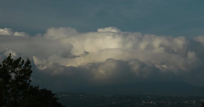 Wall of thick storm clouds slowly hovering above the hill