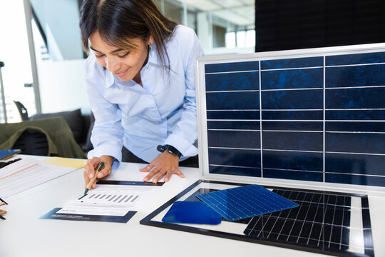 Professional in office analyzing energy consumption with solar panel