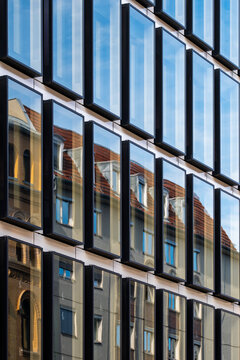 Modern architecture facade of office glass windows with urban reflections and grid pattern creating a versatile background for design