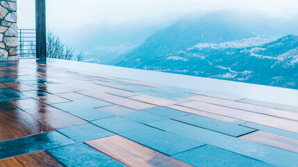 Fototapeta premium Wet, modern deck with wood and slate tiles overlooks misty, blue mountain landscape with distant village on cloudy day