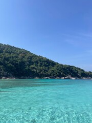 Obraz premium Exotic tropical island with crystal clear turquoise water and lush green hills