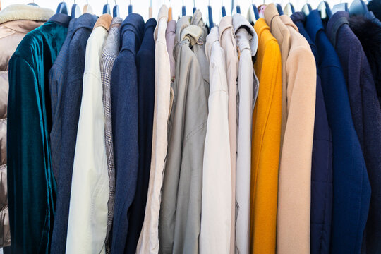 Row of second hand jackets and denim on clothing rack in shop