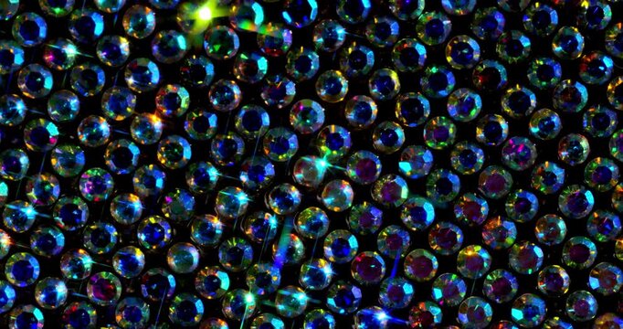 Rotating Sparkling Crystals with Star Flares. Macro video of faceted rhinestones with intense blue star flares and smooth rotational camera movement on dark surface.