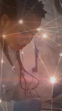 Vertical video: Tech leaning, picking tool as gloved hands prompt medical task, star overlay moving