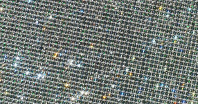 Rotating Sparkling Crystals with Star Flares. Macro video of faceted crystals sparkling intensely with smooth rotational camera movement on white surface.
