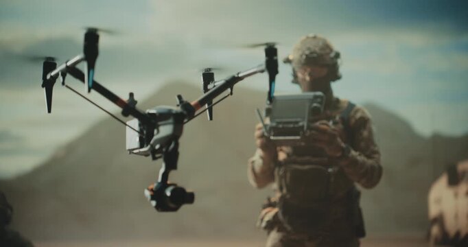 Special Forces Drone Operator Hovers a Tactical Quadcopter Drone at a Desert Base, Battlefield Mapping, Precision Strike, Target Tracking,Reconnaissance With a Control Station Modern Warfare War