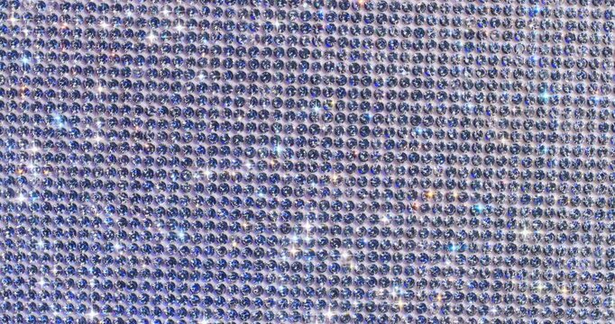 Rotating Sparkling Crystals with Star Flares. Macro video of faceted crystals sparkling intensely with smooth rotational camera movement on white surface.