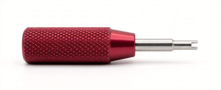 Crimson red anodized aluminum valve core remover tool with diamond knurled handle and steel tip, isolated on white.