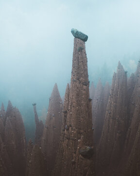 View of the Earth Pyramids of Platten stand tall, a testament to nature's artistry amid the misty landscape, Terento, Trentino-Alto Adige, Italy.