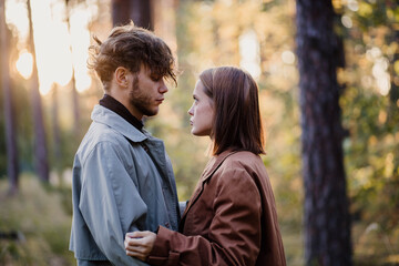 Fototapeta premium A couple in love on a date in the forest, a relationship crisis and emotional dependence