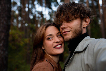 Fototapeta premium A selfie of a young beautiful couple on a walk in the forest