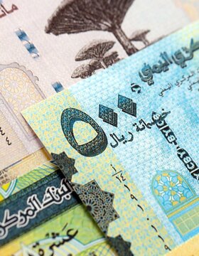 Yemeni rial paper banknotes pile on table. Yemen YER currency money bills in big amount. Concept of economics, taxation and banking in Yemen