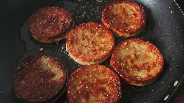 Handheld video of white pudding cooked in a pan with oil.