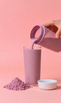 Mixing a protein beverage, pouring a pink strawberry shake into a glass to represent a food supplement idea