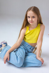 Fototapeta premium Happy little girl model with long blondie hair. Emotional, cheerful, joyful, cute, adorable caucasin girl posing in studio