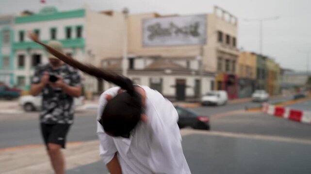 Young woman with sunglasses and a long braid dancing modern hip hop in a city street setting
