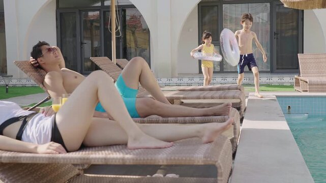A young family relaxes poolside, enjoying their getaway