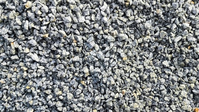 Small stone texture background. Small pieces of hard rocks or granite. close up of gray macadam stones on ground
