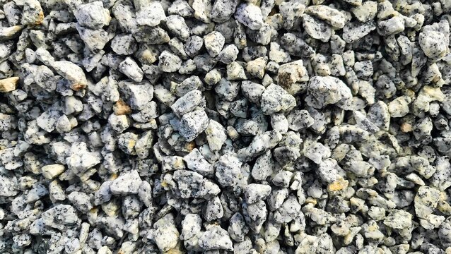 Small stone texture background. Small pieces of hard rocks or granite. close up of gray macadam stones on ground