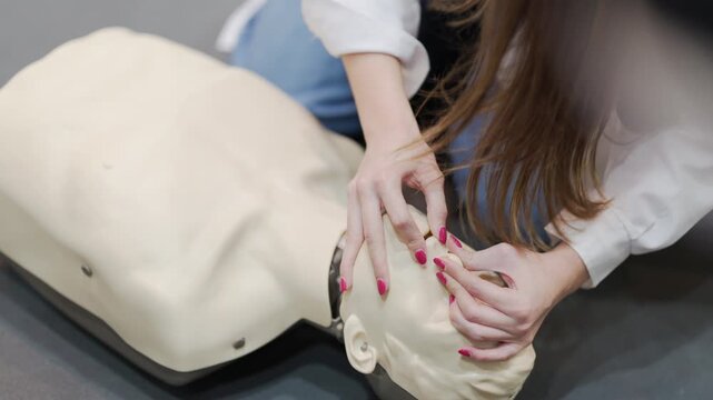 Medical student practicing rescue breathing on a cpr mannequin