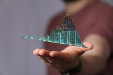 Close up of a hand holding a glowing digital graph representing financial data, business success,...