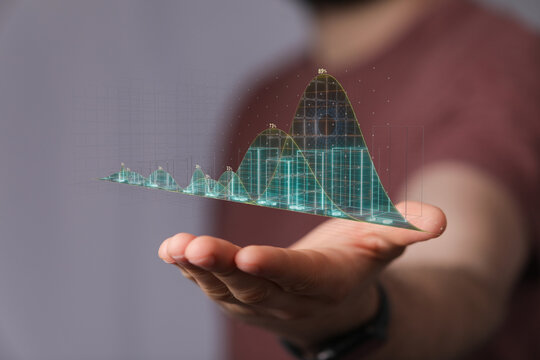 Close up of a hand holding a glowing digital graph representing financial data, business success, and innovation. Visual