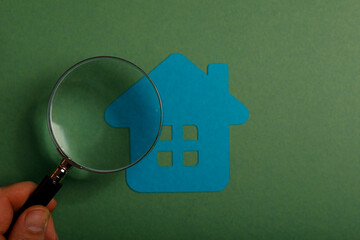 Concept of searching for a new home, real estate, and property research. Magnifying glass examining...