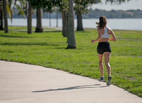 Woman running on a sunny day along the water